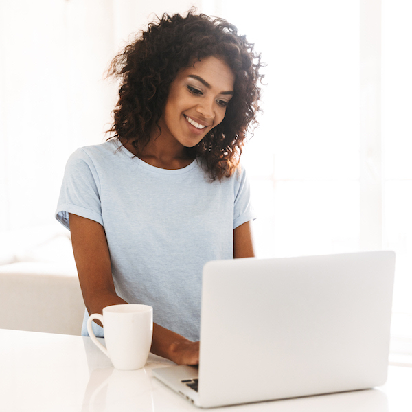 Smiling african woman using laptop computer
